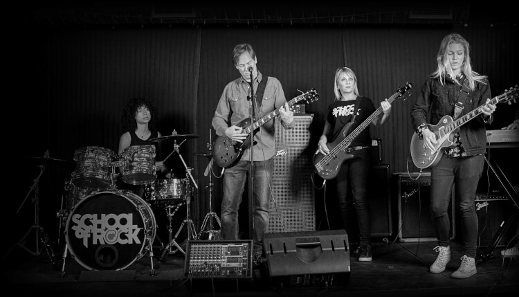 Adults playing onstage at School of Rock