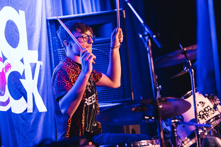 School of Rock student drummer performing on stage