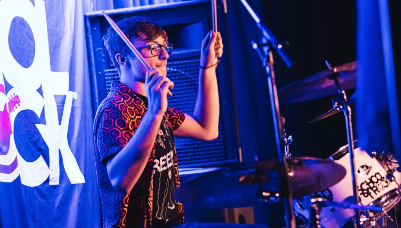 School of Rock student drummer performing on stage