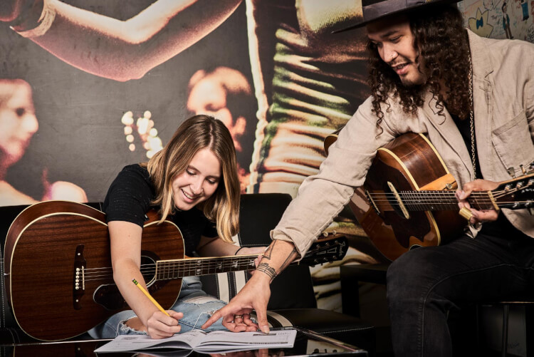 School of Rock student songwriting with music teacher