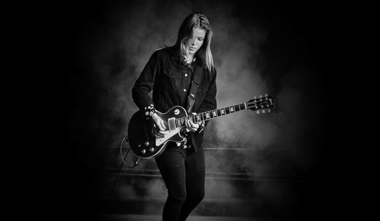 female student learning to play guitar