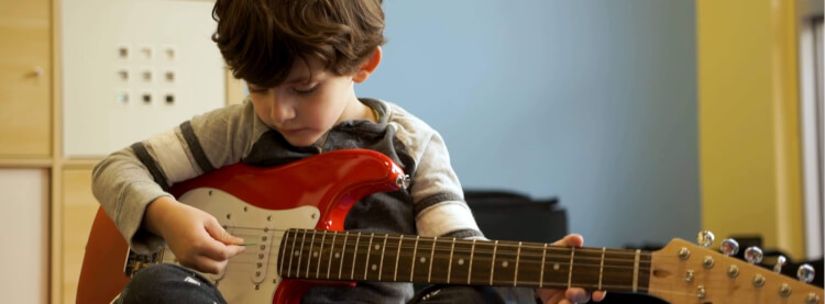 Student holding an instrument in music lessons for preschoolers